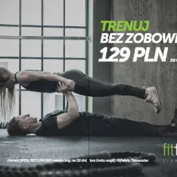 Akrobatyczny duet w fitness klubie FitFabric: mężczyzna leżący na podłodze podnosi kobietę w pozycji poziomej na wyprostowanych rękach, w tle okno z kratami i hasło 'Trenuj bez zobowiązań 129 PLN...