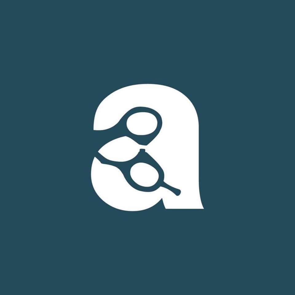 Stylizowane logo w kolorze białym na ciemnoniebieskim tle, przedstawiające literę 'a' uformowaną z kształtu nożyczek.