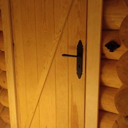 Stylowe drzwi do łazienki znajdującej się obok sauny.