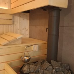 Na  zdjęciu piec opalany drewnem z 160 kg kamieni wulkanicznych. Do paleniska podkłada się drewno z poza sauny. Nad piecem znajduje się misa do aromaterapii.