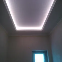 Sufit podwieszany z oświetleniem LED w kształcie kwadratu, widok z dołu, ściany w kolorze złamanej bieli, widoczne okno.