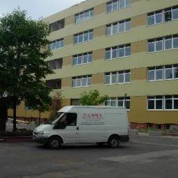 Ocieplony blok mieszkalny z widocznym firmowym busem P.H.U. MARBUD