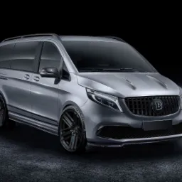 Szary, zmodyfikowany van z czarnymi felgami i grillem z logo 'B' w Wojkowicach, prezentowany na ciemnym tle.