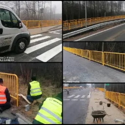 Żółte bariery ochronne montowane wzdłuż drogi i przejścia dla pieszych w Wysocko Małe, widoczni pracownicy w kamizelkach odblaskowych.