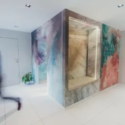 Wnętrze biura z oryginalną aranżacją ścian w odcieniach akwareli, w tle rozmazana sylwetka biegnącego mężczyzny, w rogu logo pracowni projektowej.