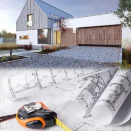 Wizualizacja nowoczesnego domu jednorodzinnego z dwuspadowym dachem i drewnianą bramą garażową, na pierwszym planie zwinięte plany architektoniczne z naniesionymi wymiarami i pomarańczowo-czarna...