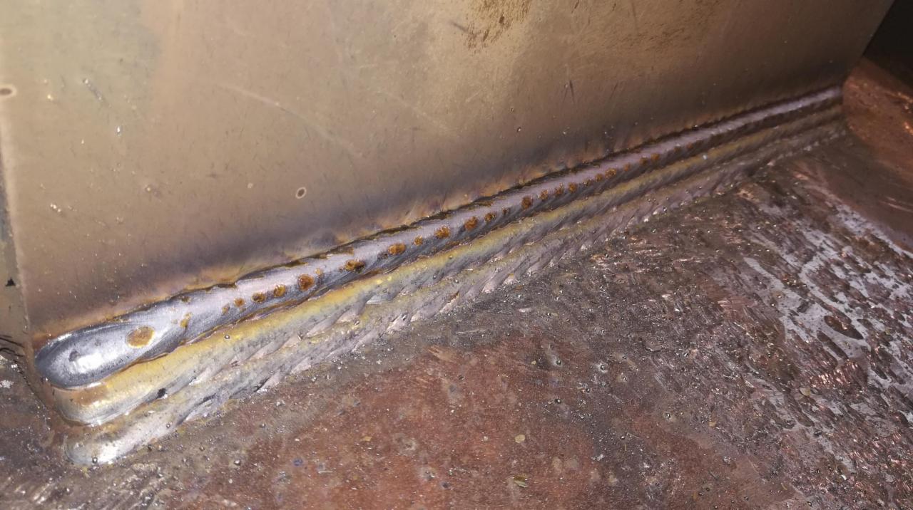 Spoina narożna wykonana metodą MIG/MAG, widoczne ślady po procesie spawania i niedoskonałości spoiny.