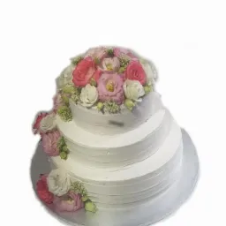 Trzypiętrowy tort weselny z białym kremem i dekoracją z różowych i białych róż oraz zielonych dodatków, umieszczony na srebrnej tacy.