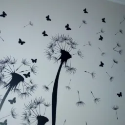 Ściana z naklejkami przedstawiającymi dmuchawce i motyle w kolorze czarnym.