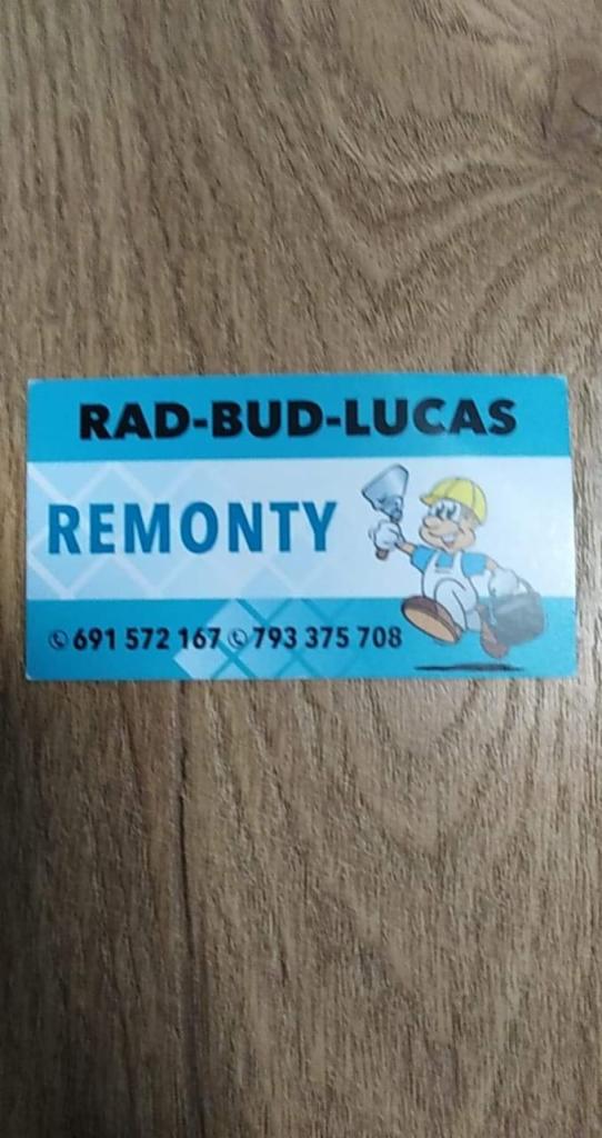 Niebieska wizytówka firmy remontowej Rad-Bud-Lucas z numerami telefonów i ilustracją murarza z kielnią na tle drewnianej powierzchni. Nazwa firmy i słowo 'Remonty' są wyróżnione.