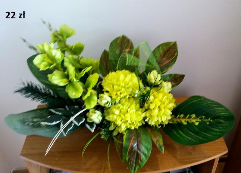 Kompozycja kwiatowa ze sztucznych, żółto-zielonych kwiatów i liści na drewnianym stoliku, widoczna cena '22 zł' w lewym górnym rogu.