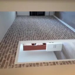 Ściana wykończona tapetą imitującą cegłę, widok z góry na fragment pomieszczenia z drewnianą podłogą i białymi listwami przypodłogowymi.