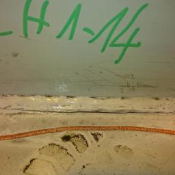 QNDT Adam Mękwiński - Szczegółowe ujęcie spoiny konstrukcji stalowej z widocznymi oznaczeniami zielonym markerem 'CH 1-14' oraz pomarańczową linią pomocniczą.