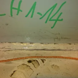 Szczegółowe ujęcie spoiny konstrukcji stalowej z widocznymi oznaczeniami zielonym markerem 'CH 1-14' oraz pomarańczową linią pomocniczą.