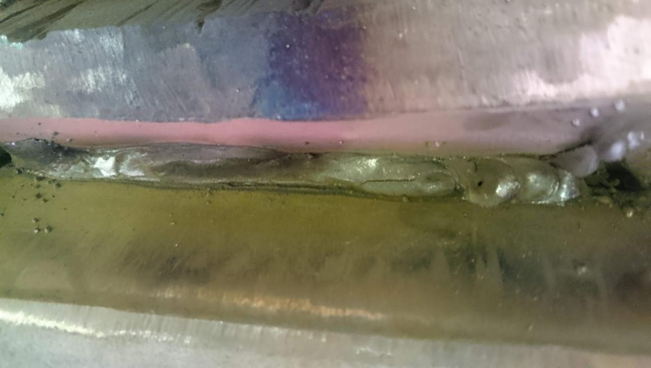 Zbliżenie spoiny łączącej elementy konstrukcji stalowej, widoczne nierówności i przebarwienia metalu.