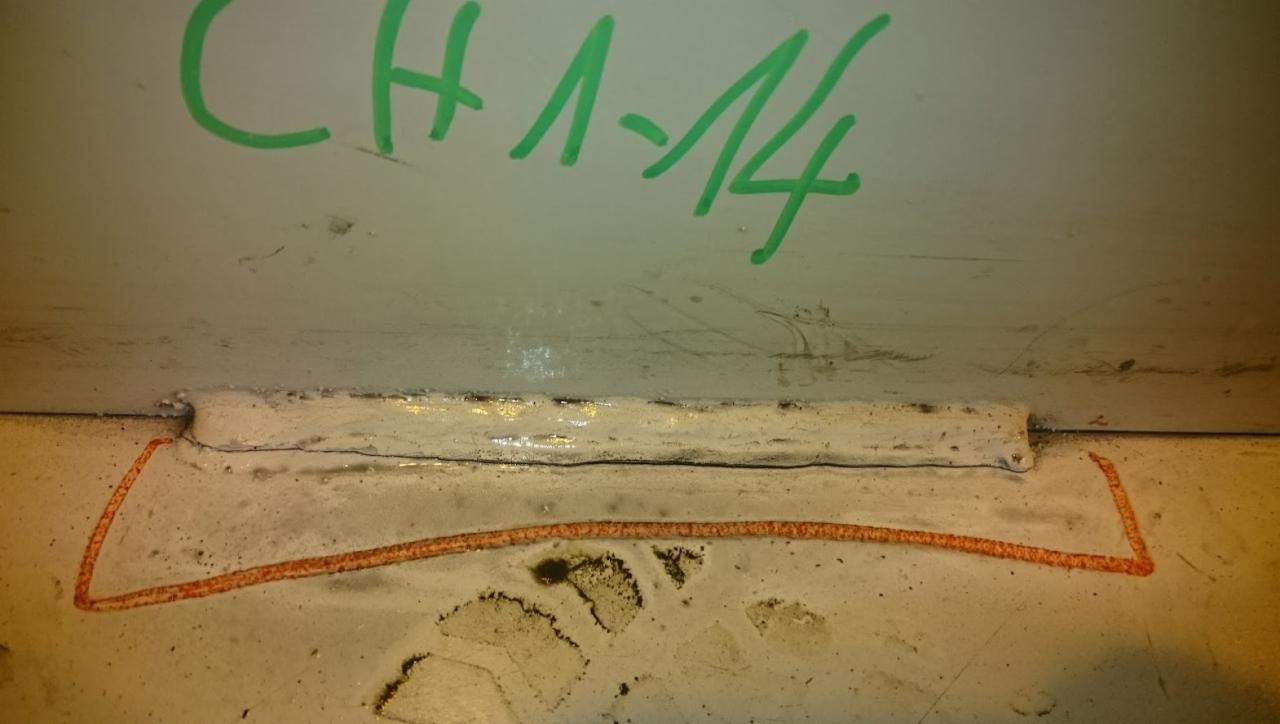 Szczegółowe ujęcie spoiny konstrukcji stalowej z widocznymi oznaczeniami zielonym markerem 'CH 1-14' oraz pomarańczową linią pomocniczą.