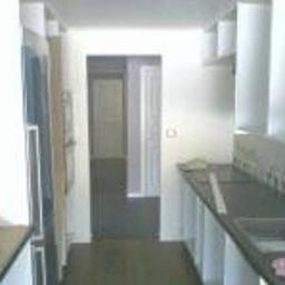 USŁUGI OGÓLNOBUDOWLANE Krzysztof Ptaś - Wąska kuchnia w trakcie remontu, widoczne przygotowane blaty, brak wykończenia ścian, perspektywa w głąb mieszkania.