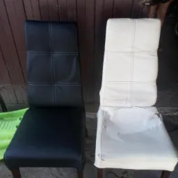 Porównanie krzesła po renowacji (czarne, skórzane obicie) z krzesłem przed renowacją (białe, zniszczone obicie).