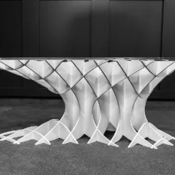 Biały, geometryczny stół z przezroczystym blatem na tle ciemnej ściany i podłogi.