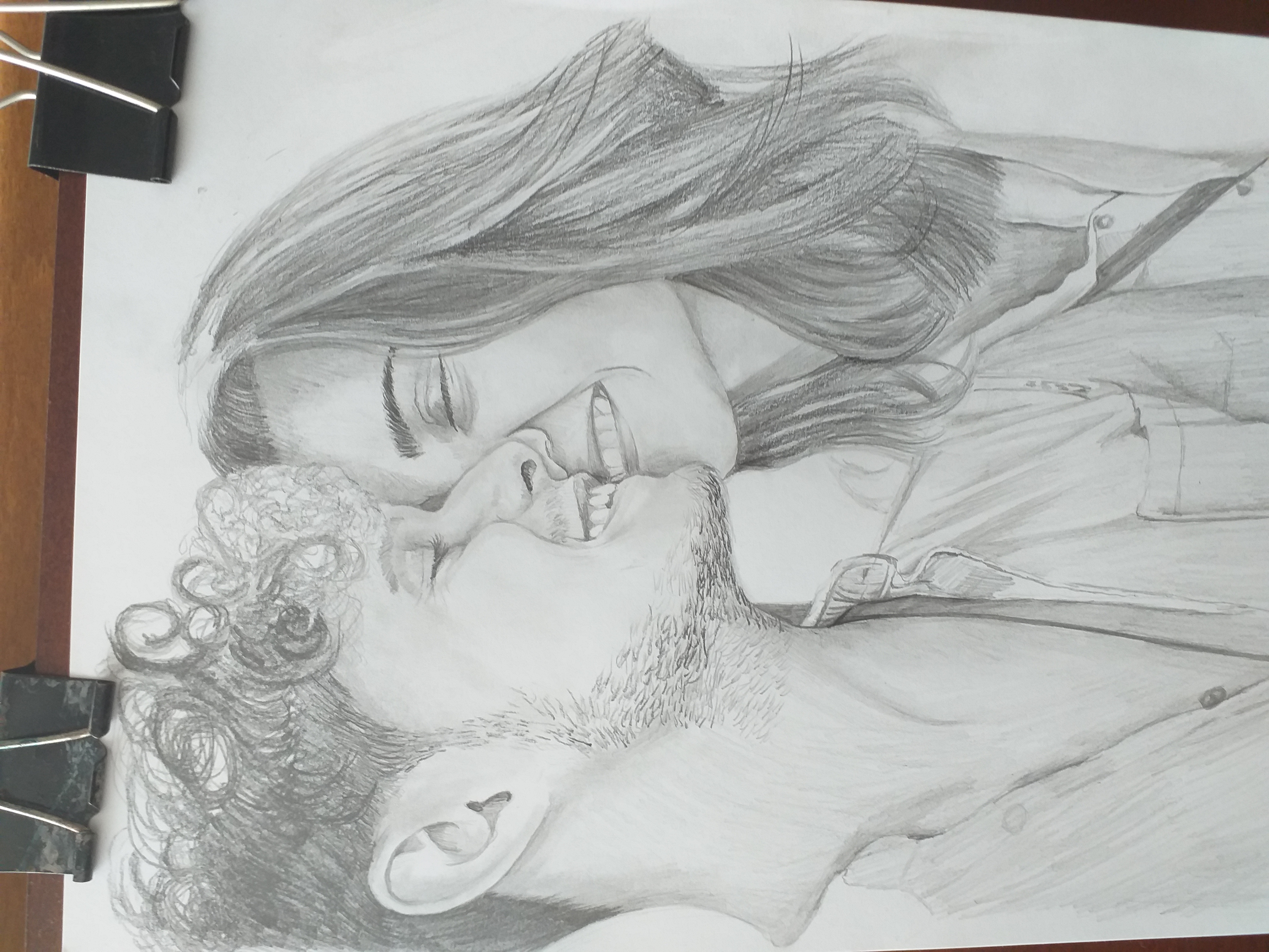 Szkic ołówkiem przedstawiający parę, widoczny na białym papierze z czarnymi klipsami po bokach.