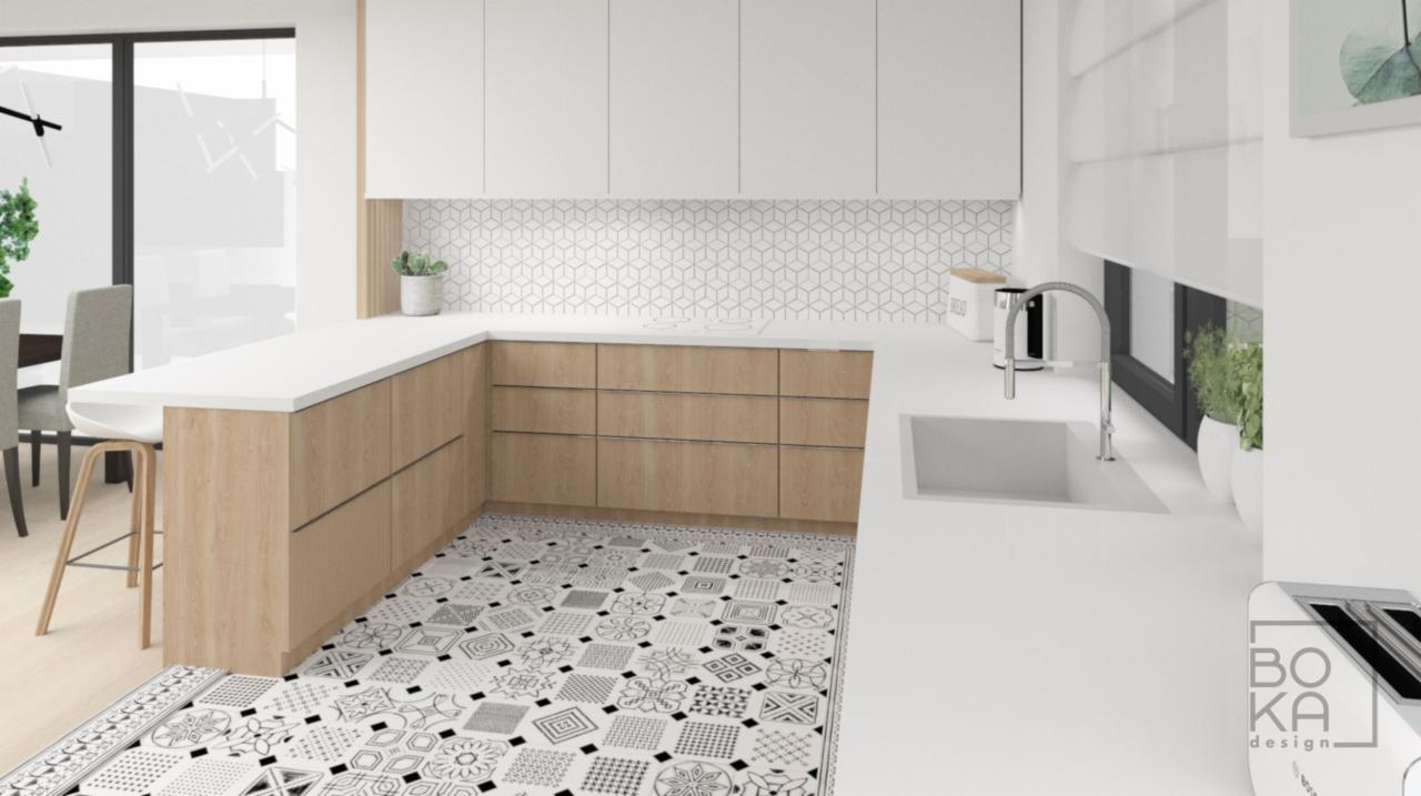 Wizualizacja jasnej kuchni z drewnianymi szafkami, białym blatem, wzorzystą podłogą i mozaiką na ścianie. Widoczny zlew, bateria, okno z roletą i elementy dekoracyjne. W tle stół z krzesłami.