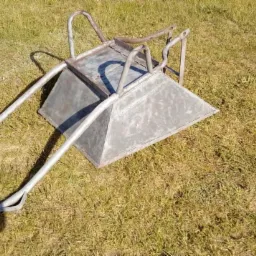 Metalowa konstrukcja wózka po obróbce, leżąca na trawie w Nowych Karmonkach, widoczne ślady po czyszczeniu.