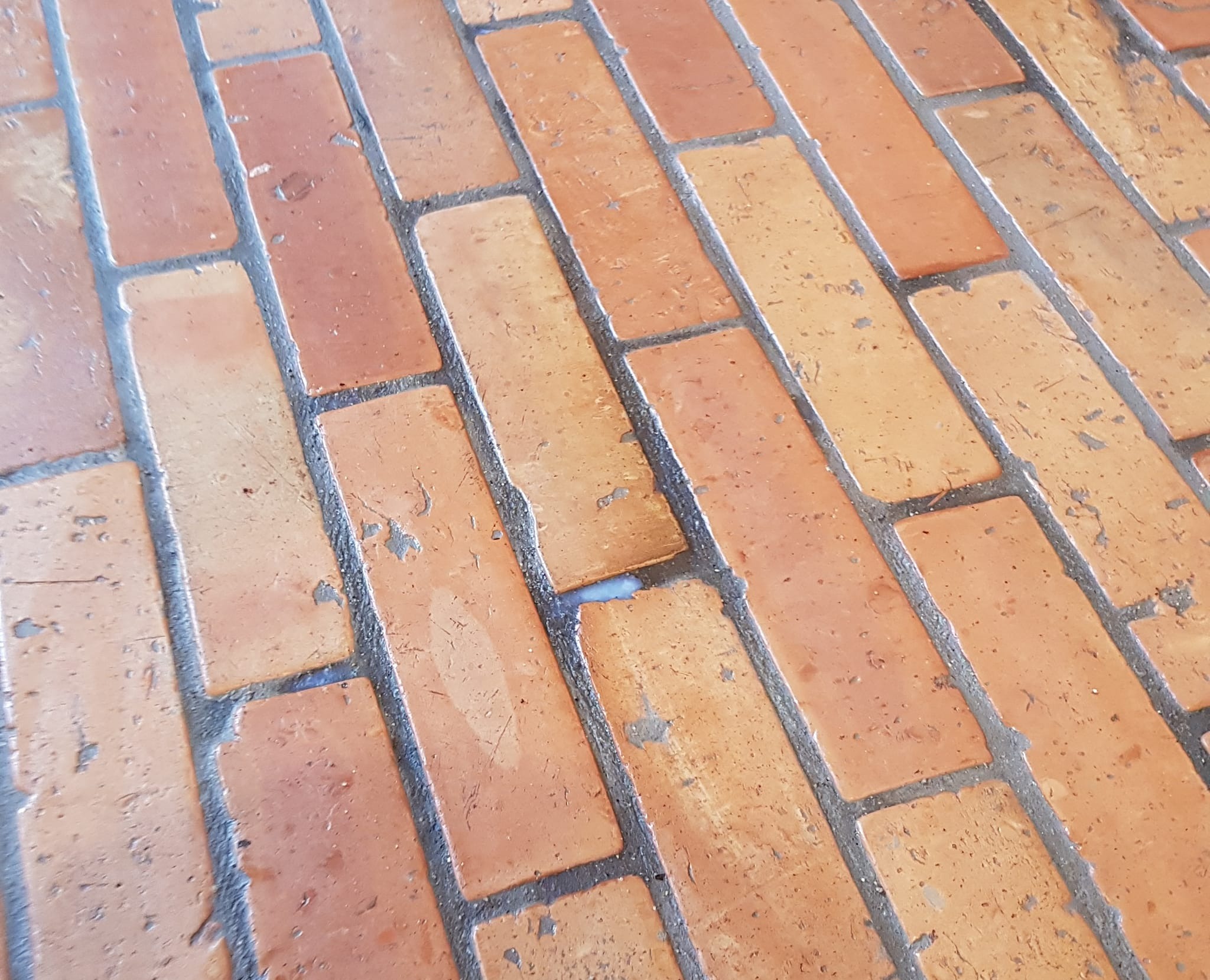 Ukończona podłoga z cegieł w stylu loft, z widocznymi fugami i naturalną kolorystyką cegieł. Detal wykończenia podłogi w stylu 'Mazurska Loft'.