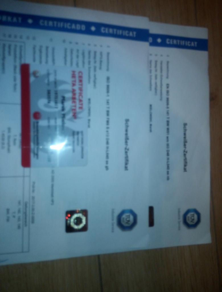 Skan dokumentu z certyfikatem spawalniczym i hologramem, widoczne logo TÜV.