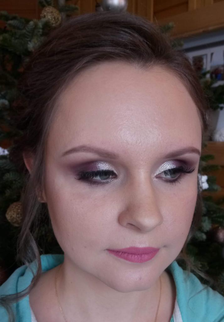 Portret kobiety z profesjonalnym wieczorowym make-upem: srebrzyste cienie na powiekach, fioletowe akcenty, różowe usta, delikatnie podkreślone brwi, rozświetlona cera.