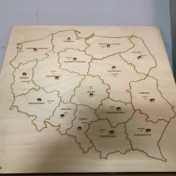 FRENO Spółka z ograniczoną odpowiedzialnością - Drewniana mapa Polski z wygrawerowanymi granicami województw i nazwami miast, wykonana techniką laserową, widoczny znak firmowy SOLVENT-KA w lewym dolnym rogu.