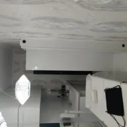 Nowoczesna łazienka z białymi meblami, ozdobnym sufitem i designerskimi lampami wiszącymi.