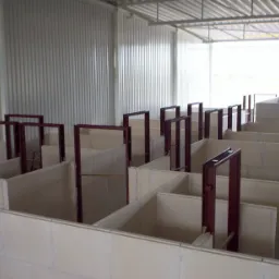 Wnętrze hali z wzniesionymi ścianami działowymi z płyt oraz stalowymi ościeżnicami, widok z góry.