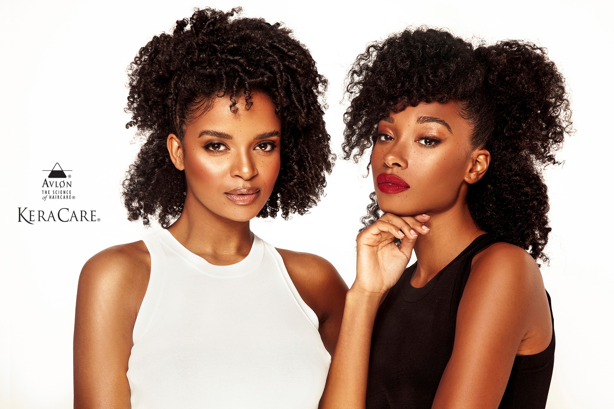 Dwie modelki o ciemnej karnacji z kręconymi włosami prezentują produkty do pielęgnacji włosów marki KeraCare na białym tle.