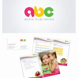 Komplet materiałów firmowych ABC Media Publishing: logo w kolorach różowym, żółtym i zielonym, wizytówka z danymi kontaktowymi oraz otwarte broszury z grafikami i tekstem, prezentujące ofertę firmy.