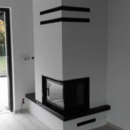 Biały narożny wkład kominkowy z czarnymi akcentami w nowoczesnym wnętrzu, widoczny z boku. Minimalistyczny design z prostymi liniami i gładkimi powierzchniami.