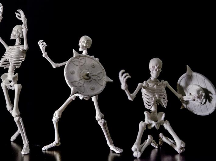 Trzy modele szkieletów wojowników z tarczami, wydrukowane w 3D w Bukowcu, na czarnym tle, ukazujące możliwości precyzyjnego modelowania.