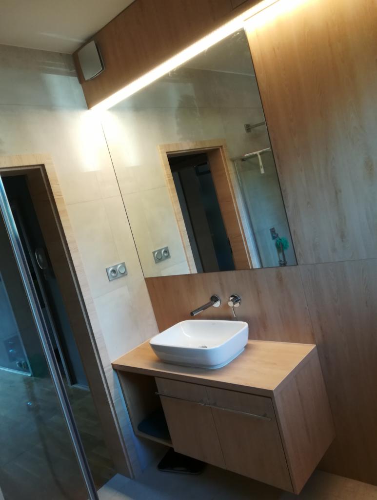 Nowoczesna łazienka z umywalką nablatową, drewnianą szafką pod umywalką i dużym lustrem z podświetleniem LED