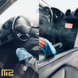 Czyszczenie parowe wnętrza samochodu Mercedes-Benz, widoczne para i niebieska ściereczka z mikrofibry, logo firmy w lewym dolnym rogu.