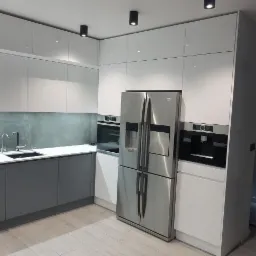 Nowoczesna kuchnia z białymi szafkami górnymi i szarymi dolnymi, srebrną lodówką side-by-side i wbudowanym ekspresem do kawy.