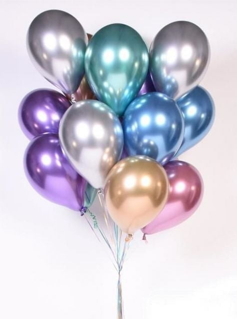 Bukiet błyszczących balonów w odcieniach srebra, fioletu, złota i błękitu, ze wstążkami, na jasnym tle.