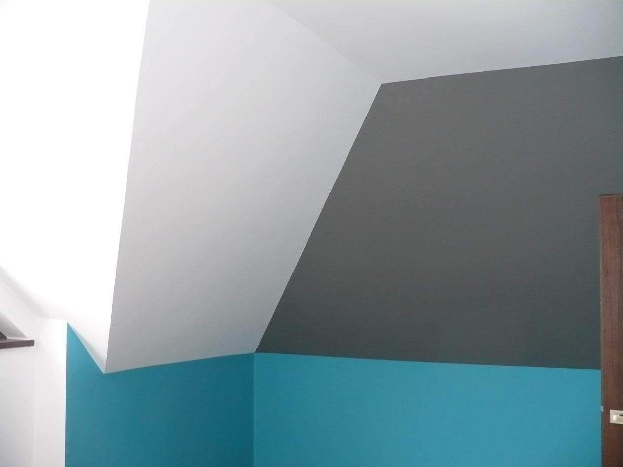 Ściana w pokoju na poddaszu pomalowana na trzy kolory: biały sufit, szara ściana i turkusowy dół, widoczny fragment drzwi.