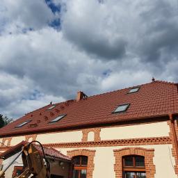 DACHY RYBKA Karol Rybka - Dom z nowym, czerwonym dachem z dachówki ceramicznej i oknami dachowymi, widoczny fragment koparki.