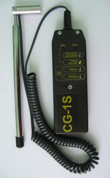 Detektor nieszczelności gazu CG-1S z sondą i przewodem spiralnym, widoczne diody sygnalizujące tryb pracy i ustawienia. Urządzenie leży na białym tle.