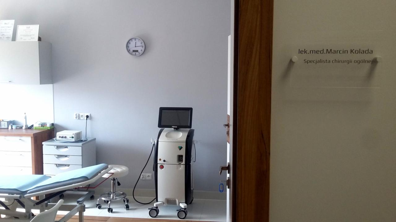Gabinet lekarski z aparaturą kosmetyczną, leżanką i tabliczką informacyjną lek. med. Marcina Kolady.