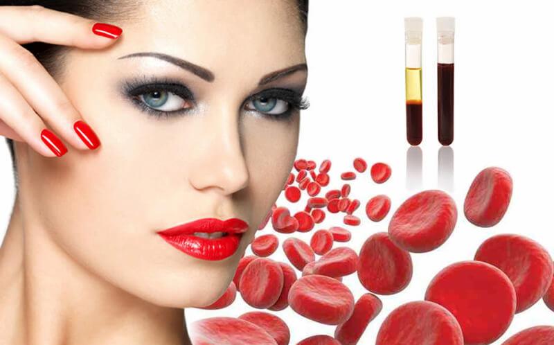 Kobieta z makijażem i czerwonymi paznokciami, obok probówek z osoczem bogatopłytkowym i czerwonymi krwinkami.