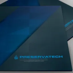 Dwa foldery firmowe w odcieniach granatu i błękitu, z logo i adresem strony internetowej, ułożone warstwowo na szarym tle.