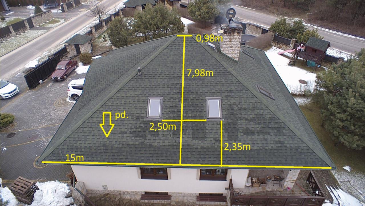 Widok z drona na dach domu pokryty grafitową dachówką bitumiczną z oknami dachowymi, oznaczony żółtymi liniami z wymiarami.