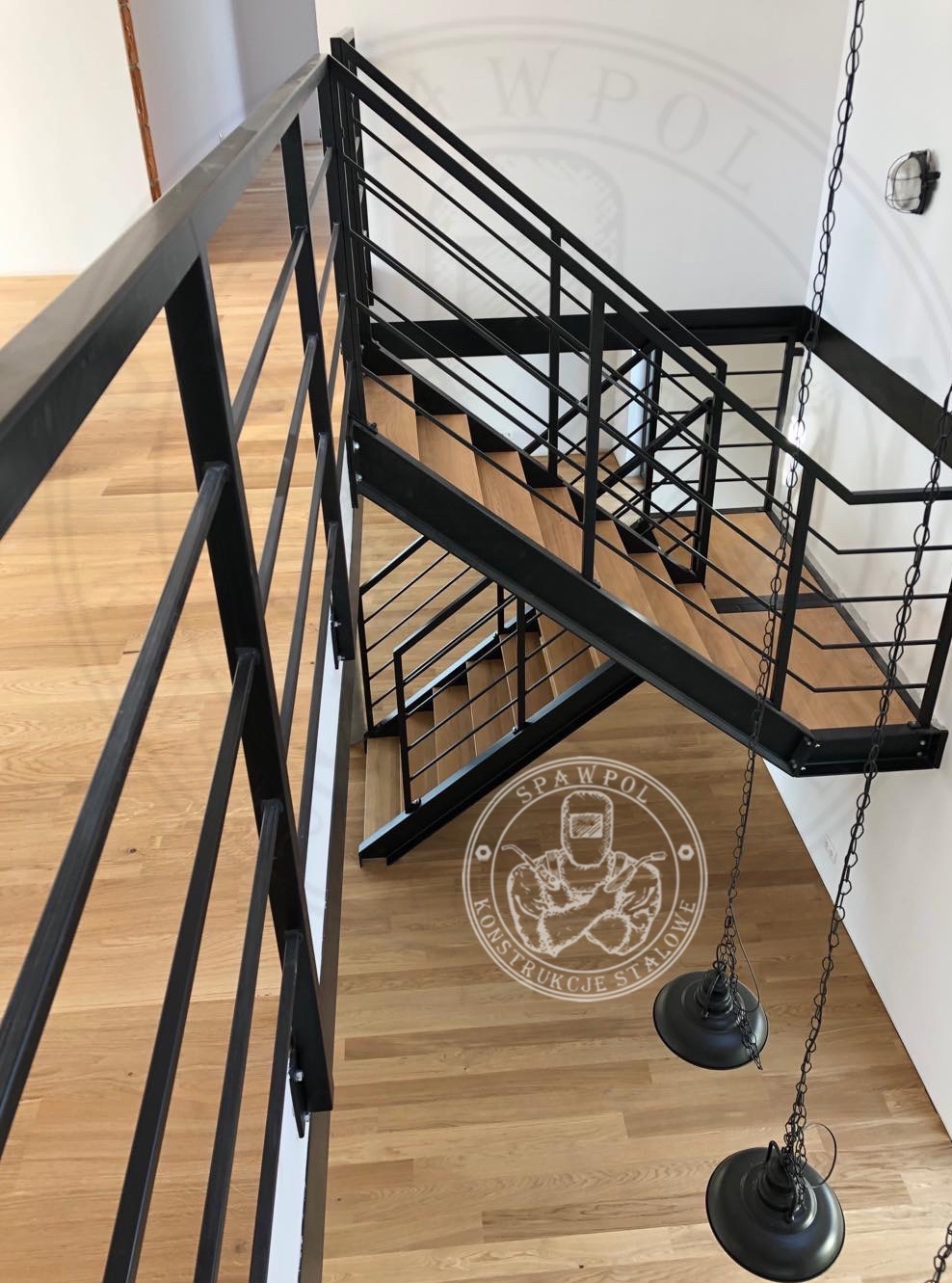 Nowoczesne schody metalowe z drewnianymi stopniami w Szczawnie-Zdroju. Minimalistyczna konstrukcja z czarnymi, prostymi balustradami i wiszącymi lampami.