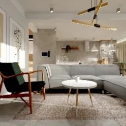 Jasne wnętrze salonu z szarym narożnikiem, okrągłym białym stolikiem kawowym, drewnianym fotelem z ciemnozielonym siedziskiem i abstrakcyjnymi obrazami na ścianie, widok na otwartą kuchnię w tle.