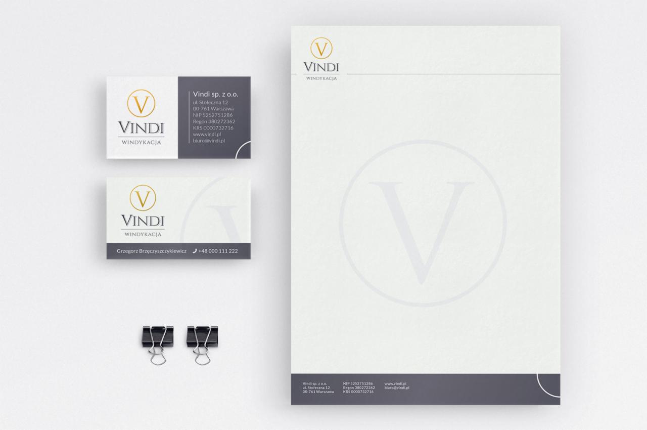 Wizualizacja identyfikacji firmy windykacyjnej: papier firmowy, dwie wizytówki i dwa spinacze biurowe na białym tle.